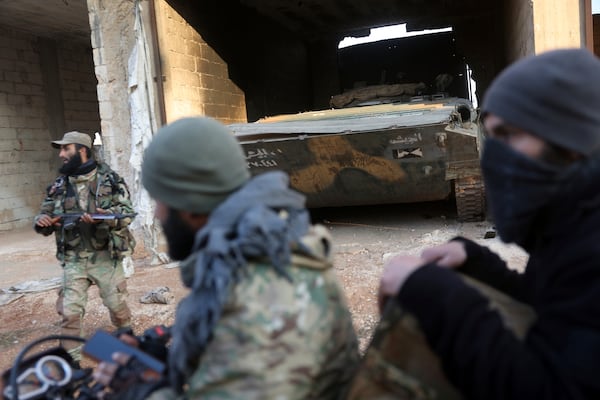 Syrian opposition fighters ride in front of a tank they allegedly captured from Syrian Government troops in Talhiya, Idlib countryside, Syria, Friday, Nov. 29, 2024. (AP Photo/Ghaith Alsayed)