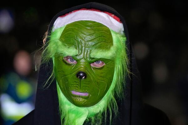 A demonstrator wearing a mask looks on during a rally outside the parliament's building to protests against the government's decision to suspend negotiations on joining the European Union, in Tbilisi, Georgia, Wednesday, Dec. 4, 2024. (AP Photo/Pavel Bednyakov)