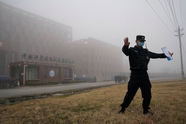 FILE - A security person moves journalists away from the Wuhan Institute of Virology after a World Health Organization team arrived for a field visit in Wuhan in China's Hubei province, Feb. 3, 2021. (AP Photo/Ng Han Guan, File)