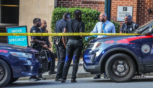 Officers and investigators roped off the entrance to the Pharr Road parking deck while they investigated a shooting Friday at the Alexan Buckhead Village apartments.