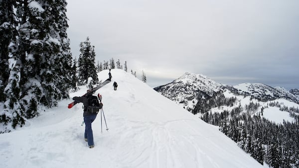 After a short rope-tow ride to the top of Sunrise Ridge, skiers and snowboards hike along the ridge to access untracked runs. Mount Angeles, 6,454 feet in elevation, is in the background on the right. (Caitlin Moran/The Seattle Times/TNS)