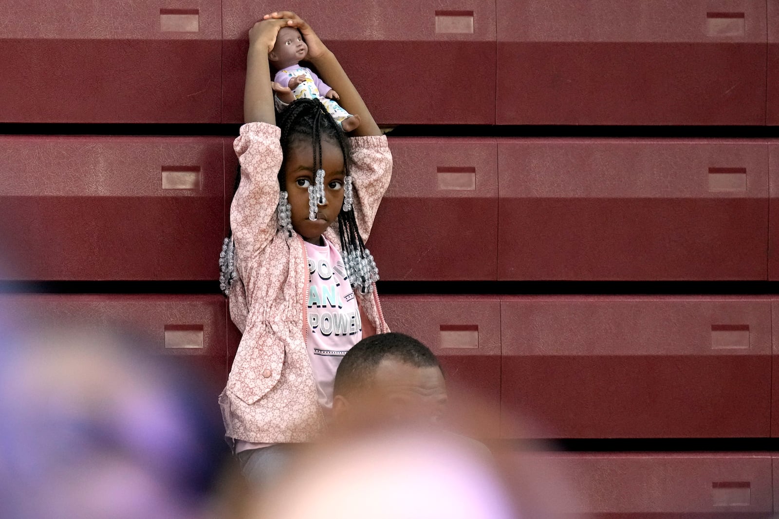 A young attendee waits for Democratic presidential nominee Vice President Kamala Harris to speak at a campaign event at Western International High School in Detroit, Saturday, Oct. 19, 2024. (AP Photo/Jacquelyn Martin)