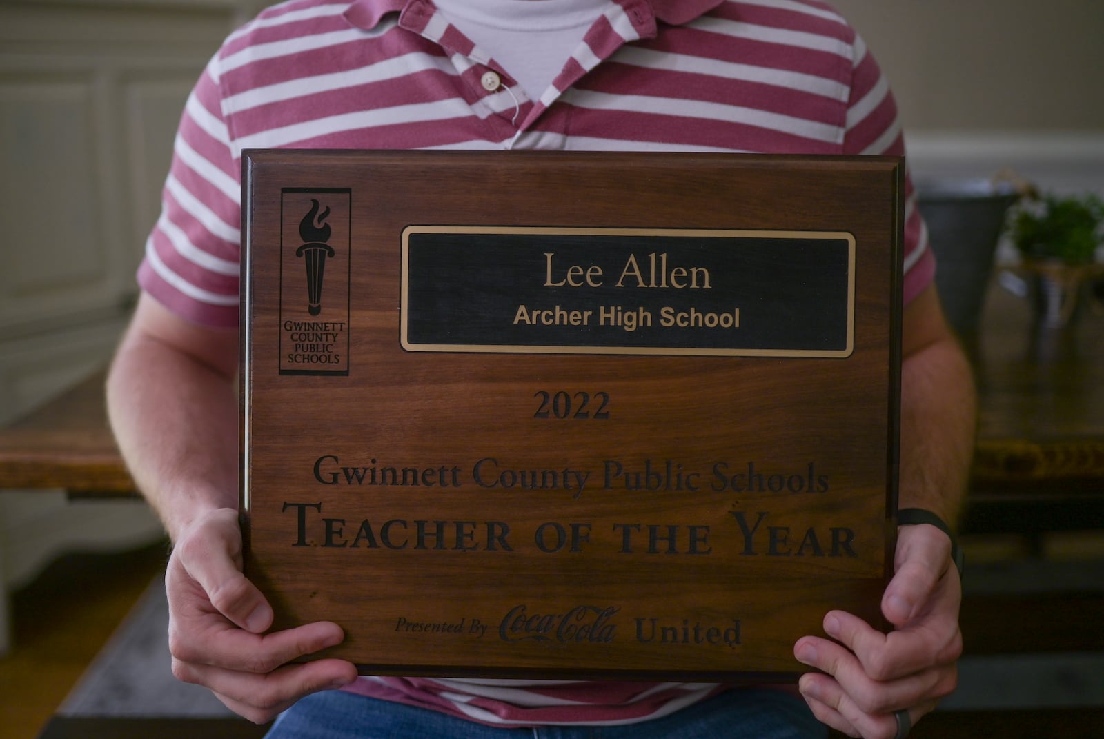 Lee Allen holds his teacher of the year plaque on Thursday, May 12, 2022. (Natrice Miller / natrice.miller@ajc.com)