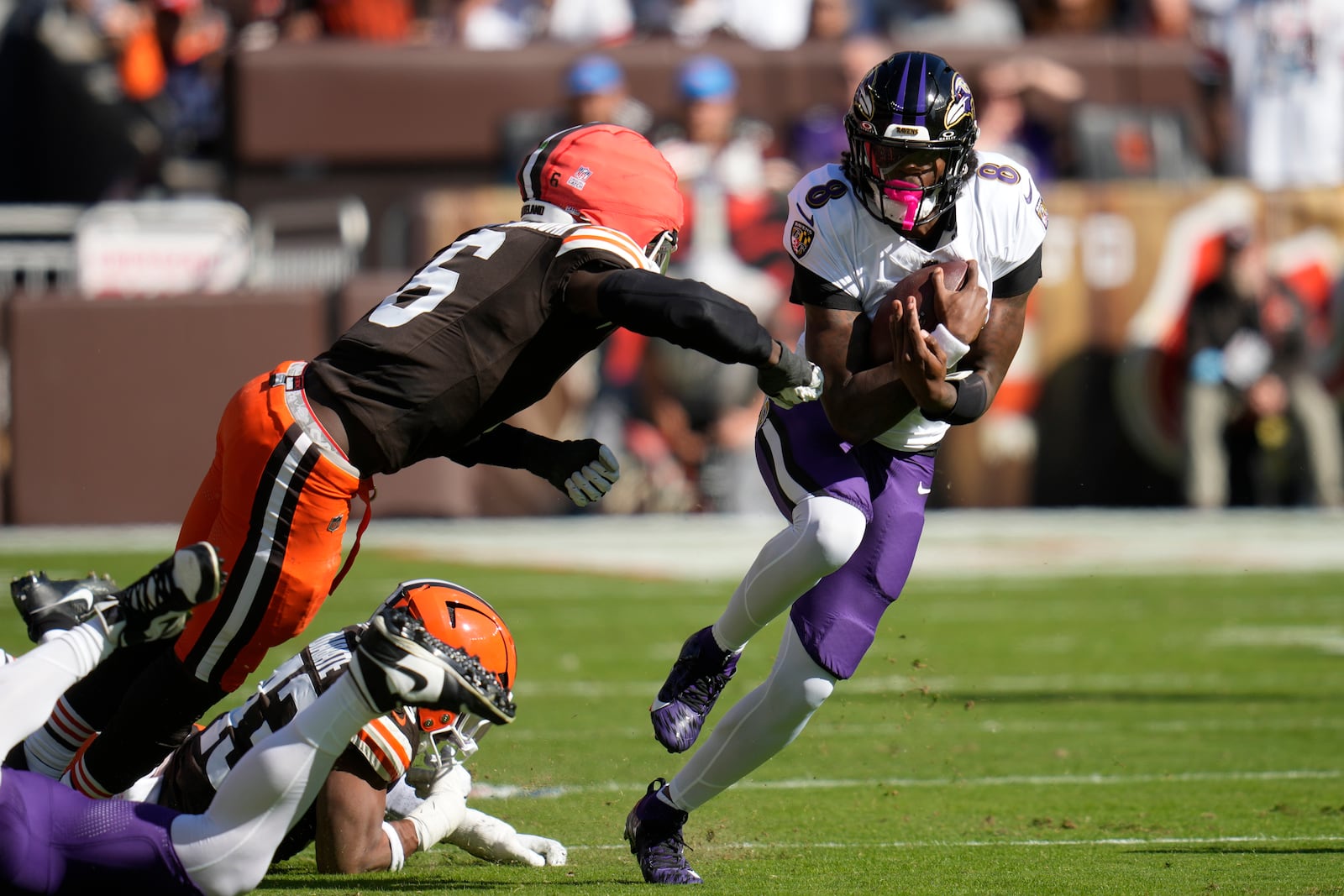 Baltimore Ravens quarterback Lamar Jackson (8) cuts past Cleveland Browns linebacker Jeremiah Owusu-Koramoah (6)\ during the first half of an NFL football game in Cleveland, Sunday, Oct. 27, 2024. (AP Photo/Sue Ogrocki)