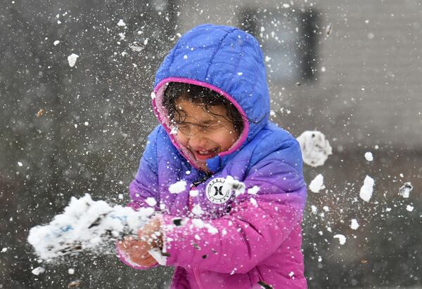 January 16, 2022 Lawrenceville - Isabel Goicochea, 7, reacts as she gets hit by a snowball in Lawrenceville on Sunday, January 16, 2022. Snowfall continues to move south of I-285 and south Fulton and Coweta counties could see up to 2 inches of snow by Sunday evening. Major impacts near Lake Lanier and into the North Georgia mountains are being felt and certain spots could see up to 10 inches of snow. As of around noon, snow is moving through Troup and Coweta counties, as Fayette and Clayton counties still patiently wait for some flurries amidst the rain and some wintry mix. (Hyosub Shin / Hyosub.Shin@ajc.com)