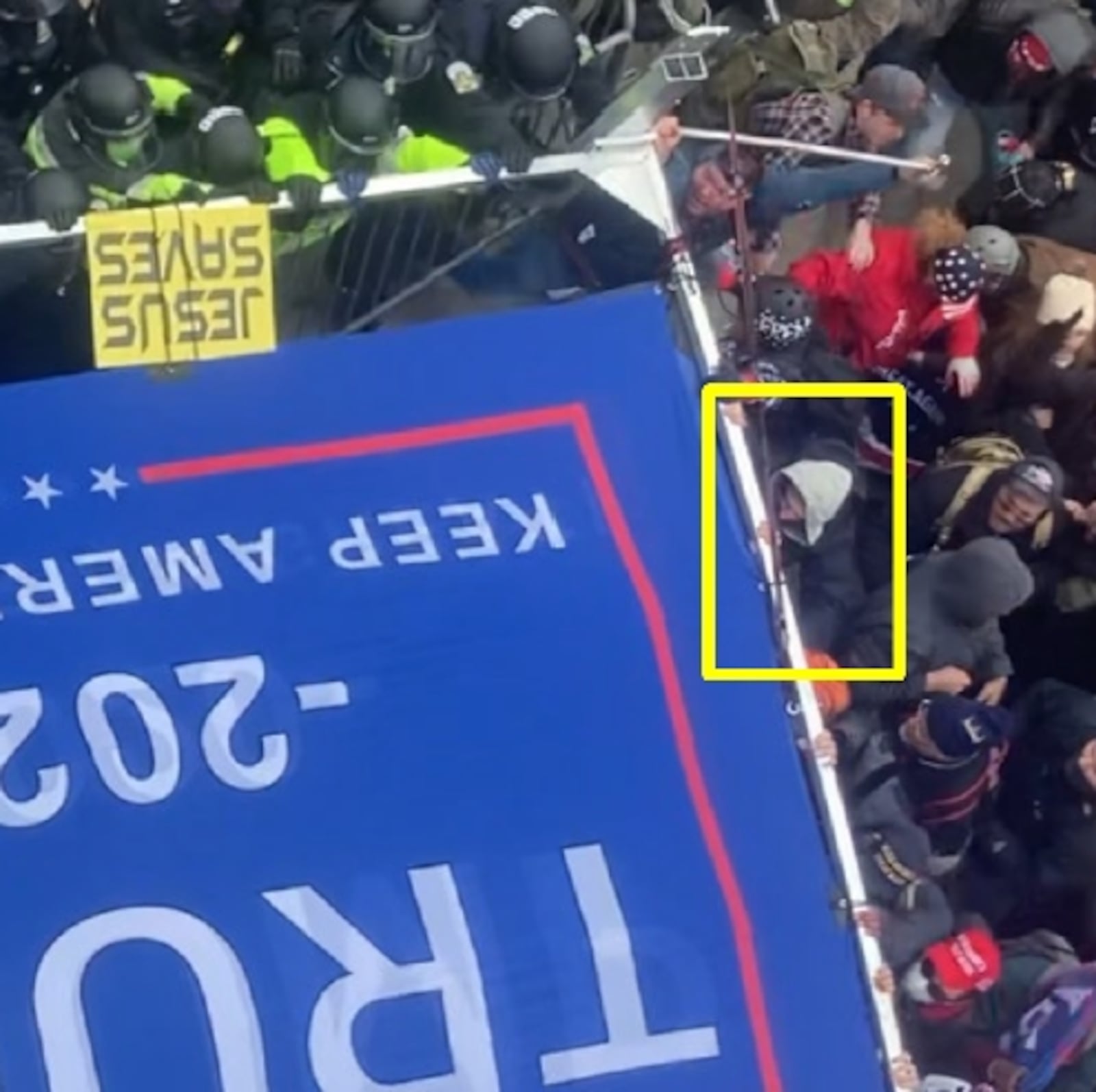 Federal investigators say a person they identified as Milton resident Cylester Maxwell (circled) joined with others during the Jan. 6, 2021, U.S. Capitol riot to assault police with a large, metal-framed Trump campaign sign.