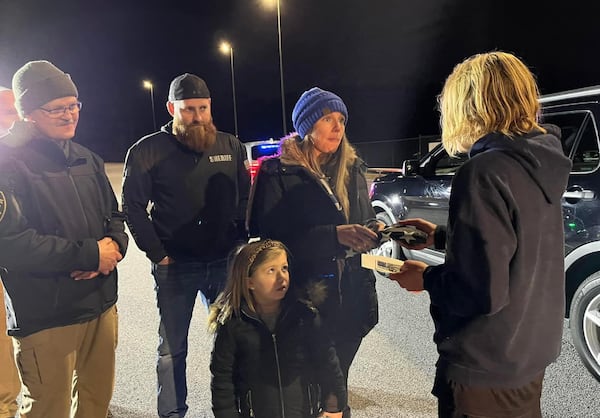 Andrew Collinson presents a flag to the family of Coweta County Deputy Eric Minix, who died in the line of duty.