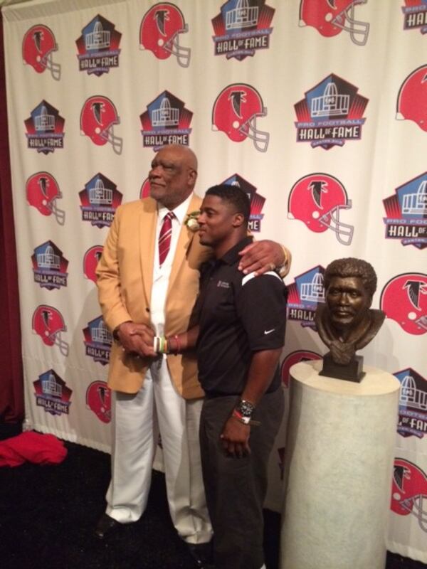 Pro Football Hall of Famer Claude Humphrey posing with former Falcons and part-owner Warrick Dunn in front of his bust after being enshrined in Canton. (D. Orlando Ledbetter/Dledbetter@ajc.com)