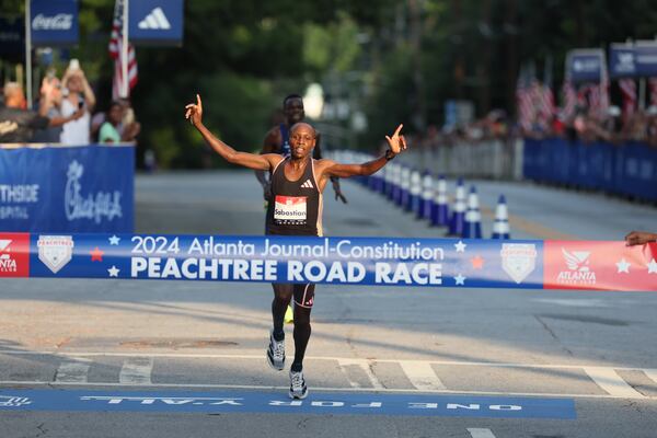 Elite men’s winner Sabastian Sawe crosses the finish line of the 55th running of the Atlanta Journal-Constitution Peachtree Road Race in Atlanta on Thursday, July 4, 2024.   (Jason Getz / AJC)