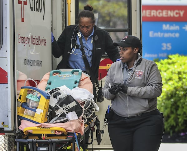 Grady Paramedic field training supervisor Christy Wheeler (left) and advanced emergency medical technician Laquandrea Hollingsworth (right) finish a patient transport at Children’s Healthcare of Atlanta — Hughes Spalding Hospital at 35 Jesse Hill Jr. Drive SE in Atlanta on Thursday, April 2, 2020. JOHN SPINK/JSPINK@AJC.COM