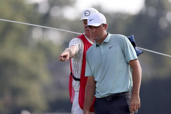 Scottie Scheffler and his caddie Ted Scott confer over a shot on the eighth green during the third round of the Tour Championship at East Lake Golf Club, Saturday, August 27, 2022, in Atlanta. (Jason Getz / Jason.Getz@ajc.com)