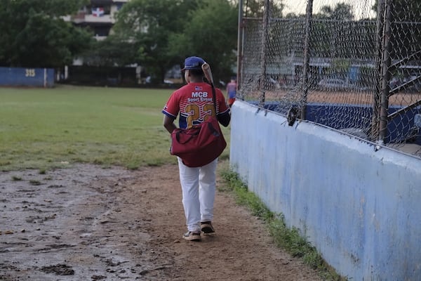 A teenage baseball player, wearing an MCB Sport Event jersey, arrives for practice at the Trinitarios ballpark in Santo Domingo, Dominican Republic, Wednesday, Feb. 5, 2025. (AP Photo/Ricardo Hernandez)