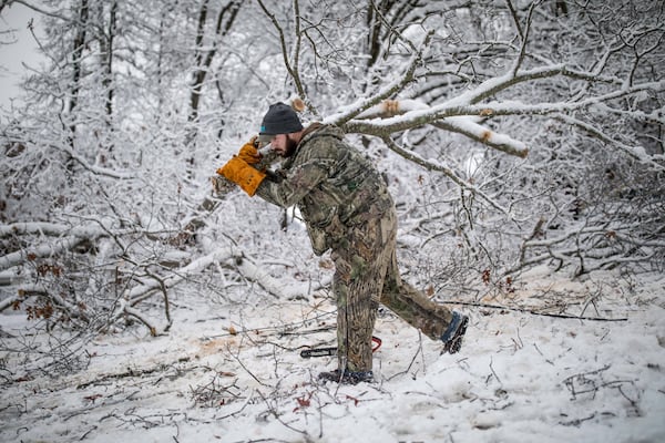 Cory Dodson works to clear a fallen tree Saturday on Wooten Lake Road in Kennesaw. Power outages hit Cobb County as well as other parts of metro Atlanta and North Georgia after snow and ice swept into the area starting Friday, Dec. 8, 2017.