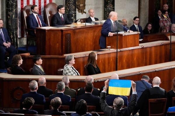 A member of Congress holds up Ukraine's flag as President Donald Trump addresses a joint session of Congress at the Capitol in Washington, Tuesday, March 4, 2025. (AP Photo/Alex Brandon)