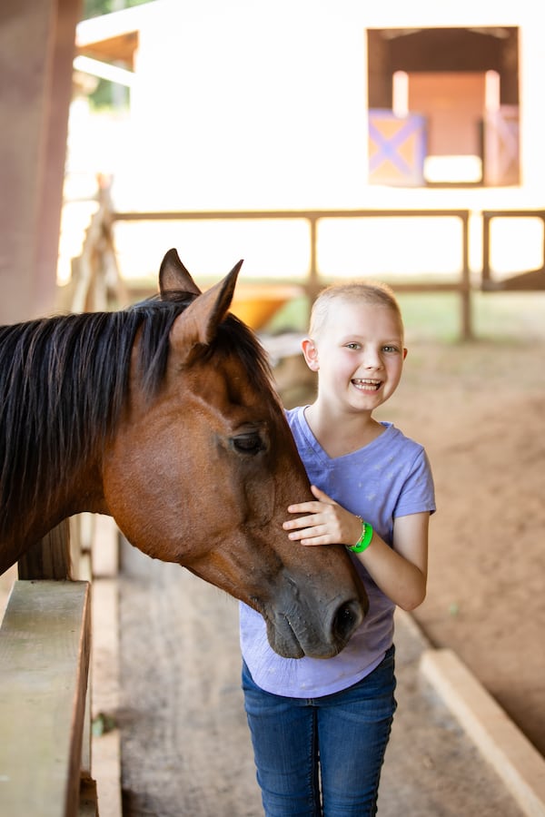 A Camp Sunshine camper pets a horse during one of the organizations June summer camps. Camp Sunshine hosts free camps for both juniors and teens who are either from Georgia, or who have been treated for cancer in Georgia.