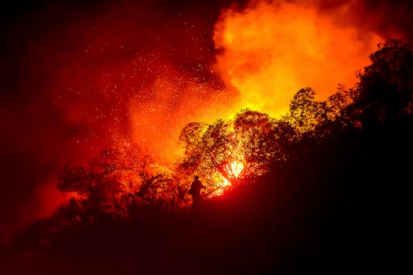 A firefighter battles the Lilac Fire near the Bonsall community of San Diego County, Calif., on Tuesday, Jan. 21, 2025. (AP Photo/Noah Berger)