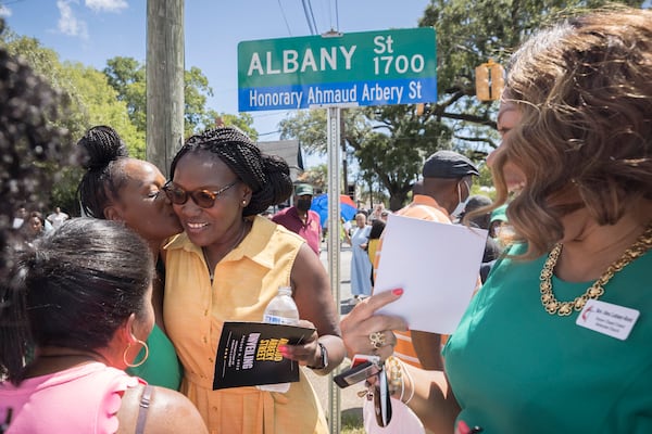 Ahmaud Arbery's mother, Wanda Cooper-Jones, is kissed by her friend Dana Roberts after a sign commemorating a downtown street in honor of her son was unveiled on Tuesday, Aug. 9, 2022, in Brunswick. (Stephen B. Morton for the AJC 2022)