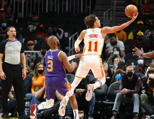 Hawks guard Trae Young goes to the basket for two past Phoenix Suns guard Chris Paul during the first half of a NBA basketball game on Thursday, Feb. 3, 2022, in Atlanta.  “Curtis Compton / Curtis.Compton@ajc.com”`