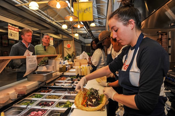 141229-ATLANTA-GA- Dine review of Todd Ginsbergs new counters Yalla and Fred's Meat & Bread, inside the Krog St Market, on Thursday January 1, 2015. Chef de Cuisine, Layla Walk, makes a Falafel Laffa at the Yalla counter. (Beckysteinphotography.com) Layla Walk rolling a laffa at Yalla