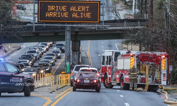 Both southbound lanes of Northside Drive were shut down for a time Wednesday morning while fire crews battled a blaze at a dry cleaning business. JOHN SPINK / JSPINK@AJC.COM