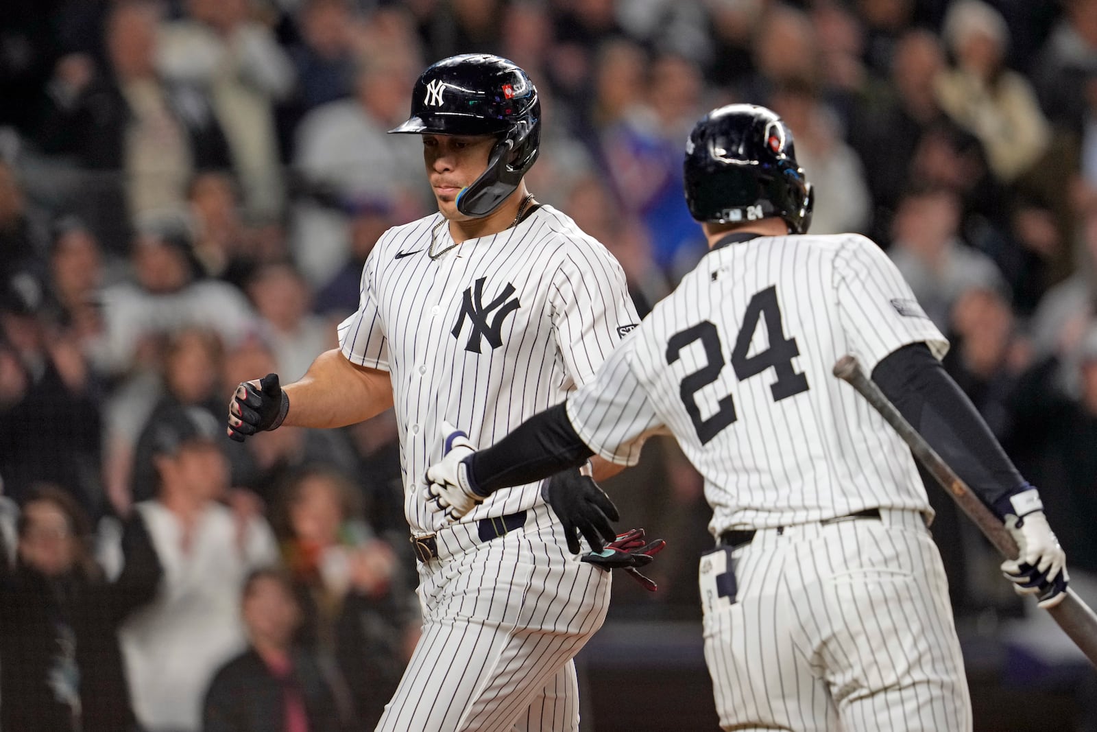 New York Yankees' Juan Soto, left, celebrates with Alex Verdugo (24) after scoring on a wild pitch against the Cleveland Guardians during the third inning in Game 1 of the baseball AL Championship Series Monday, Oct. 14, 2024, in New York. (AP Photo/Godofredo Vásquez)