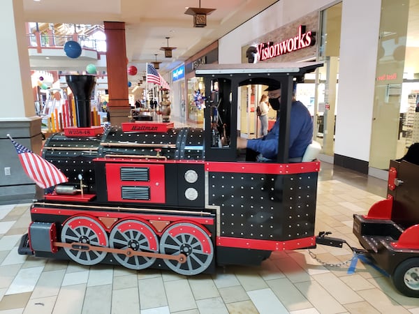 "Choo Choo" Bob, also known as Bob Banaszak, has been having an easier time this holiday season driving a train ride for kids at the Mall of Georgia in Gwinnett County. Compared to the Christmas rush in previous years, there are few shoppers he has to navigate around during the pandemic. MATT KEMPNER / AJC