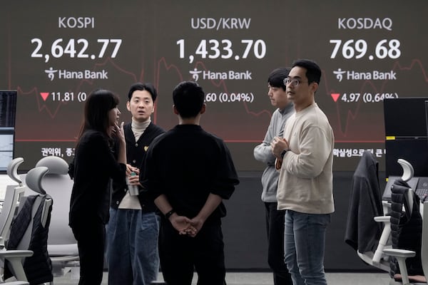 Currency traders work near a screen showing the Korea Composite Stock Price Index (KOSPI), top left, and the foreign exchange rate between U.S. dollar and South Korean won, top center, at the foreign exchange dealing room of the KEB Hana Bank headquarters in Seoul, South Korea, Monday, Feb. 24, 2025. (AP Photo/Ahn Young-joon)