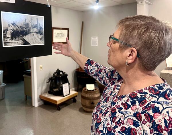 Jackson County Historical Society President Laura Cates Duncan describes a photo on display at the society's office of an elderly couple sitting on the ruins of their home after the March 18, 1925 Tri-State Tornado on March 11, 2025 in Murphysboro, Ill. (AP Photo/John O'Connor)