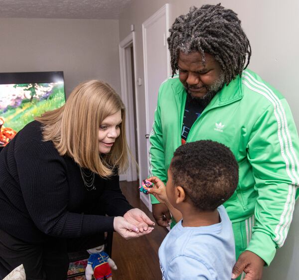 (l-r) Open Doors case navigator Jennifer Yearwood (left) listens to MJ Glenn as his father Michael Glenn watches in their Decatur home. PHIL SKINNER FOR THE ATLANTA JOURNAL-CONSTITUTION
