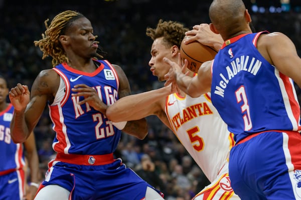 Atlanta Hawks guard Dyson Daniels (5) drives to the basket between Sacramento Kings guard Keon Ellis (23) and Jordan McLaughlin during the first half of an NBA basketball game in Sacramento, Calif., Monday, Nov. 18, 2024. (AP Photo/Randall Benton)