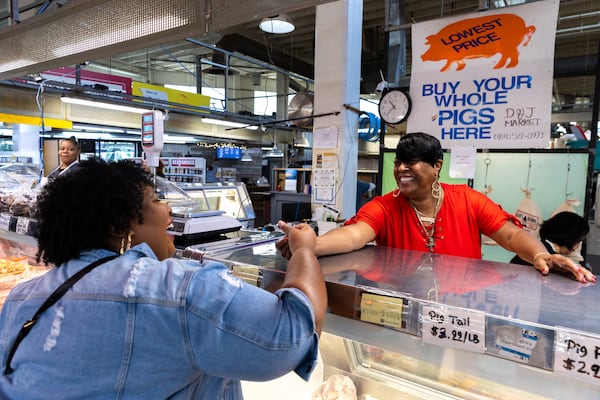 (L-R) Delronda Grant, owner of AB! Cookie Company, greets Regina Berry at D&L Meat Counter in the Municipal Market in Atlanta on Friday, October 18, 2024. (Arvin Temkar / AJC)