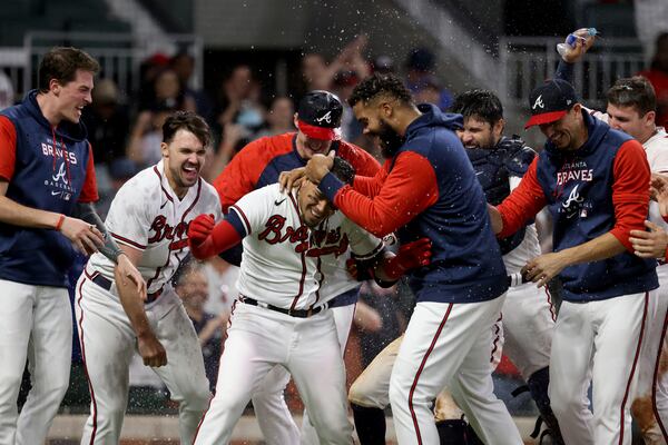 Braves designated hitter Orlando Arcia is mobbed by teammates after hitting a two-run home run for a 5-3 walk-off win against the Red Sox on Wednesday night at Truist Park. (Jason Getz / Jason.Getz@ajc.com)