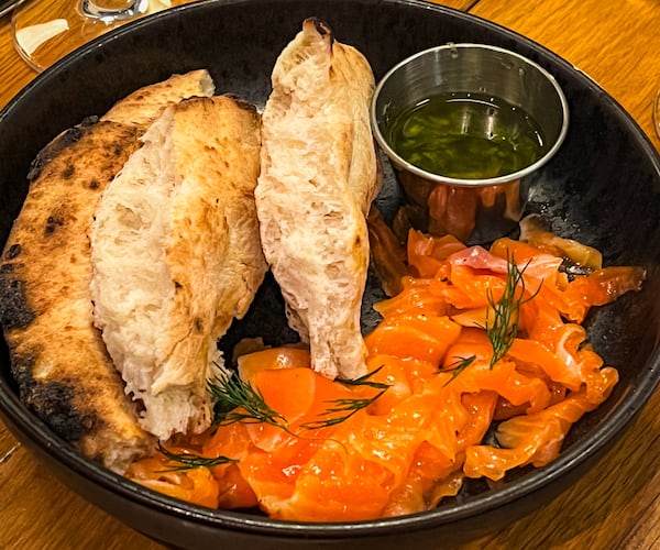 The shaved king salmon is cured and smoked in-house at Bocado and is served with grilled focaccia. (Henri Hollis/AJC)