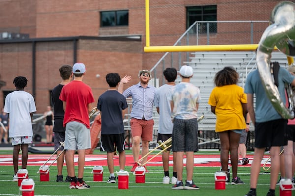 The water jugs stay nearby their owners, ready to extinguish thirst, as needed, during marching band practice at North Gwinnett High School. (Jamie Spaar for The Atlanta Journal-Constitution)