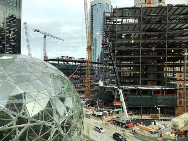 Builders work on new office towers becoming part of Amazon’s headquarters campus in downtown Seattle. (SCOTT TRUBEY / Scott.Trubey@ajc.com