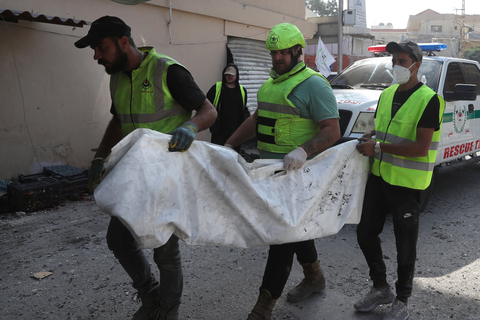 Rescue workers carry remains of killed people at the site that was hit by Israeli airstrikes in Qana village, south Lebanon, Wednesday, Oct. 16, 2024. (AP Photo/Mohammed Zaatari)