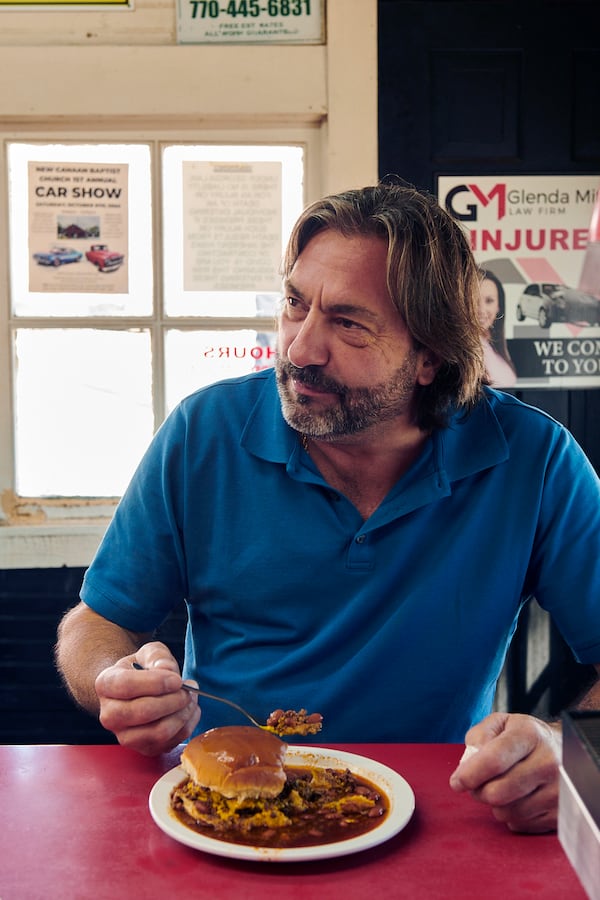 A customer has an all-the-way hot dog at the 4 Way Lunch in Cartersville. (Greg Rannells for The Atlanta Journal-Constitution)