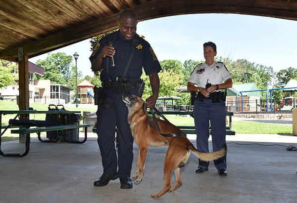 Deputy Sheriff Michael McRae, Viper’s handler, celebrates the K-9 deputy’s retirement as Major L. J. Roscoe, field services division commander, looks on.