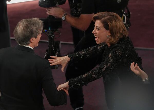 Fernanda Torres, right, congratulates Walter Salles after he wins the award for "I'm Still Here" from Brazil, for best international feature film during the Oscars on Sunday, March 2, 2025, at the Dolby Theatre in Los Angeles. (AP Photo/Chris Pizzello)