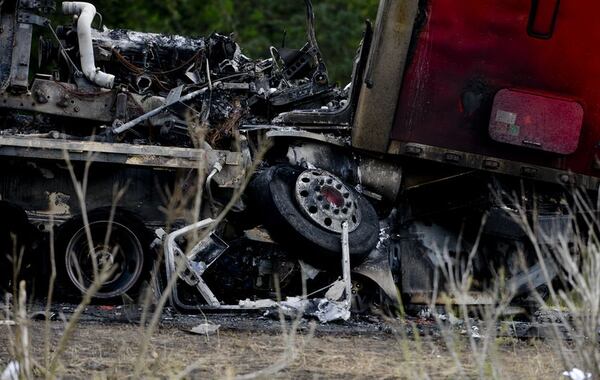 A tractor trailer sits on top of a crushed car after a multiple car accident on I-16 in Pooler, Ga. on Tuesday, May 19, 2015. (Ian Maule/Savannah Morning News via AP)