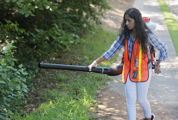 Urmila Poudel, a seasonal staff member from the DeKalb County Health Department’s Division of Environmental Health, spreads larvicide pellets in a culvert to help control mosquitoes. After a stretch of heavy rains, mosquitoes tend to multiply. This year, testing is showing an unusually high number of mosquitoes testing positive for West Nile virus. BOB ANDRES /BANDRES@AJC.COM