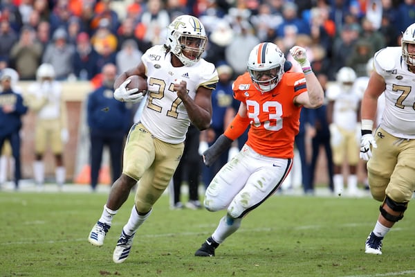 Jordan Mason #27 of the Georgia Tech Yellow Jackets rushes past Zane Zandier #33 of the Virginia Cavaliers in the second half during a game at Scott Stadium on November 9, 2019 in Charlottesville, Virginia. (Photo by Ryan M. Kelly/Getty Images)