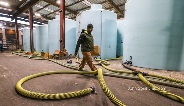 Randy Walker walks by 10,000-gallon brine tanks at the Georgia Department of Transportation facility in Forest Park.