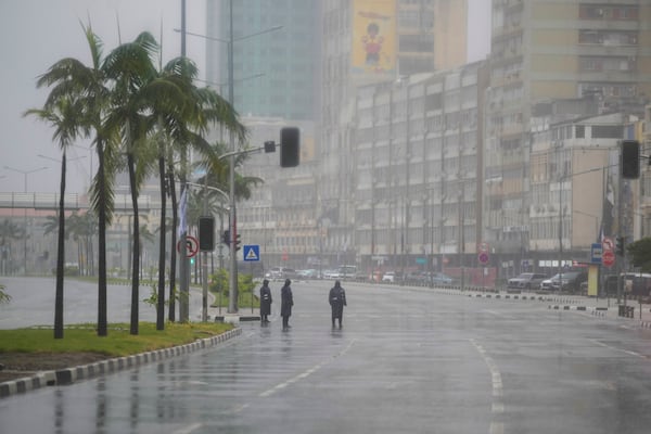 Seen through a vehicle window, Angolan soldiers stand on the route of President Joe Biden's motorcade in the rain in the capital Luanda, Angola on Tuesday, Dec. 3, 2024. (AP Photo/Ben Curtis)