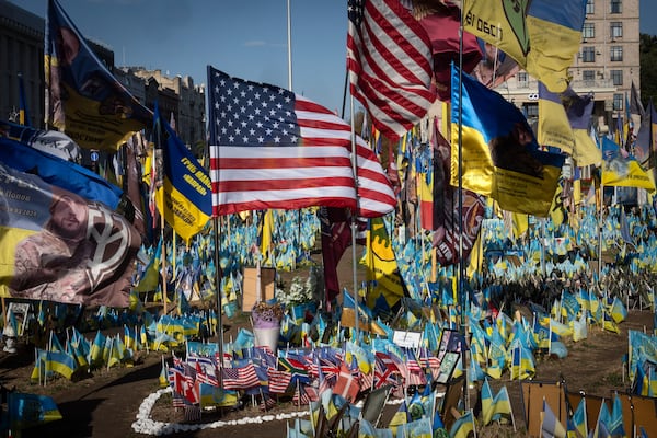 US and Ukrainian national flags wave to commemorate American volunteers, who were killed in battles with Russian troops defending Ukraine, their names are on flags, at the improvised war memorial in Independence square in Kyiv, Ukraine, Friday, Sept. 27, 2024. (AP Photo/Efrem Lukatsky)