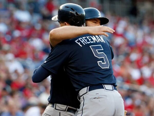 Freddie Freeman hugs Evan Gattis after Freeman's 1st-inning homer off the Nats' Stephen Strasburg on Friday. Gattis has been on fire for weeks, and now Freeman is heating up again.