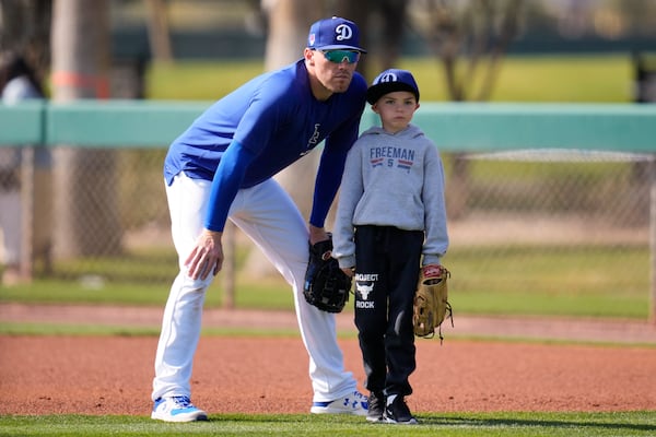 FILE - Los Angeles Dodgers first baseman Freddie Freeman, left, and his son Charlie, right, participate in spring training baseball workouts at Camelback Ranch in Phoenix, Feb. 18, 2024. (AP Photo/Ashley Landis, File)