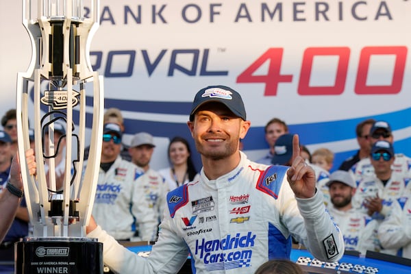 FILE - Kyle Larson poses with the trophy with his daughter Audrey, 6, after winning a NASCAR Cup Series auto race at Charlotte Motor Speedway in Concord, N.C., Oct. 13, 2024. (AP Photo/Chuck Burton, File)