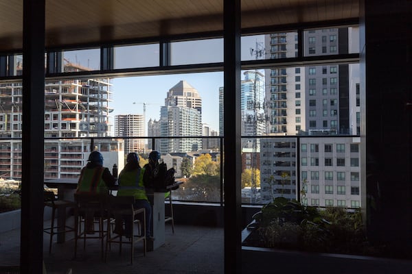 Construction workers take a break at the newly completed office tower Spring Quarter in Atlanta on Monday, December 2, 2024. It's the largest office building that will be delivered in 2024 and one of the last ones being built in Midtown of this size, likely for years. (Arvin Temkar / AJC)