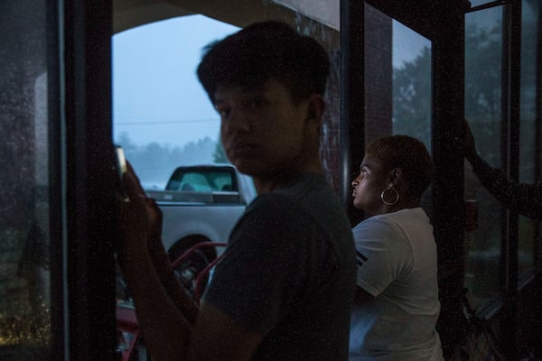 10/10/2018 -- Albany, Georgia -- Shelter seekers at New Birth Fellowship Church use their phones to record Hurricane Michael as it moves through Albany, Wednesday, October 10, 2018. New Birth Fellowship Church opened its doors to people in preparation for the hurricane. Hurricane Michael was ranked as a Category 4 storm before making landfall in the Florida Panhandle and South Georgia. (ALYSSA POINTER/ALYSSA.POINTER@AJC.COM)